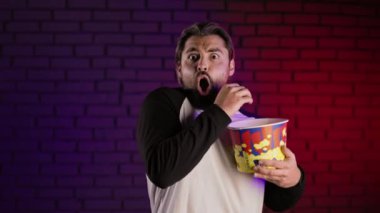 Korku filmi izleyen ve stüdyoda patlamış mısır yiyen adam.