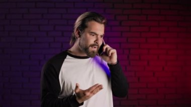 Sinirli bir adam akıllı telefonda tatsız bir konuşma yapıyor.