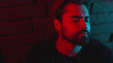 Stüdyoda otururken kendini kırılmış hisseden düşünceli adam