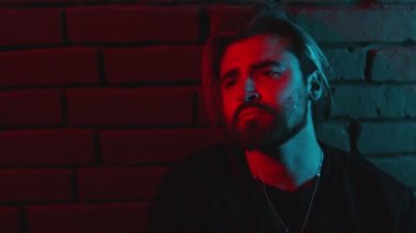 Stüdyoda oturan depresif beyaz adamın portresi.