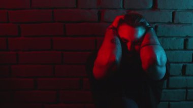 Kederli adam başını tutuyor ve duygusal olarak bağırıyor.