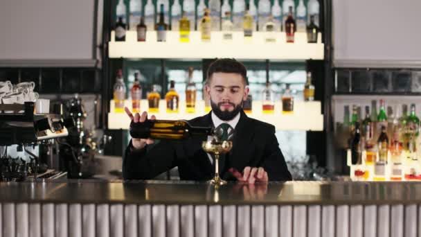 熟练的酒保站在豪华餐厅柜台后面 用金黄色的古董酒杯从瓶中倒入酒精饮料 服务和夜生活的概念 — 图库视频影像