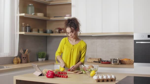 Kıvırcık Saçlı Sebze Doğrayan Taze Domates Yiyen Güzel Bir Genç — Stok video