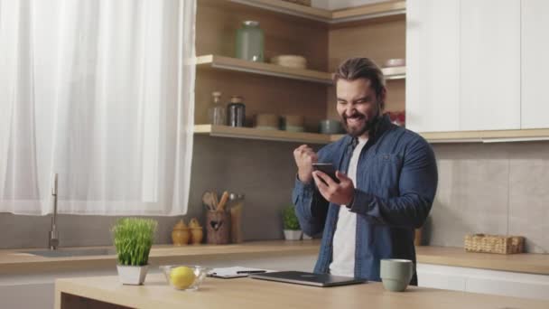 Excited Bearded Man Looking Mobile Screen Gesturing Happiness While Standing — Stock Video
