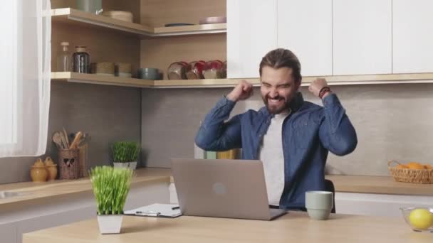 Caucasian Man Greeting Great News Work While Sitting Kitchen Desk — Vídeo de Stock