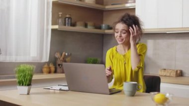 Caucasian young woman gesturing from happiness while reading good news on modern laptop. Joyful female freelance celebrating some success or achievement at work.