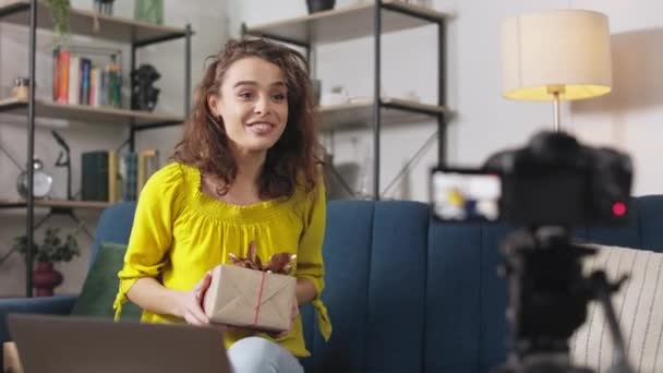 Pozitivní Ženský Blogger Kudrnatými Vlasy Sedí Pohodlné Pohovce Ukazuje Zabalené — Stock video