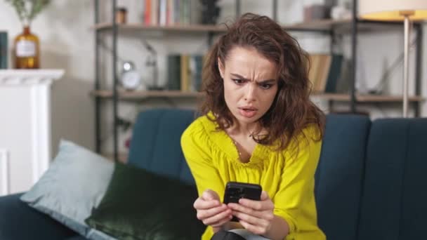 Sad Caucasian Woman Sitting Comfy Sofa Modern Smartphone Hands Upset — Stock Video