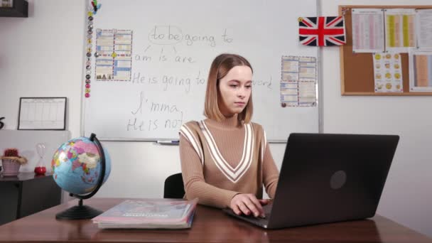 Konzentrierte Englischlehrerin Mit Tragbarem Computer Klassenzimmer Mit Whiteboard Hintergrund Junge — Stockvideo