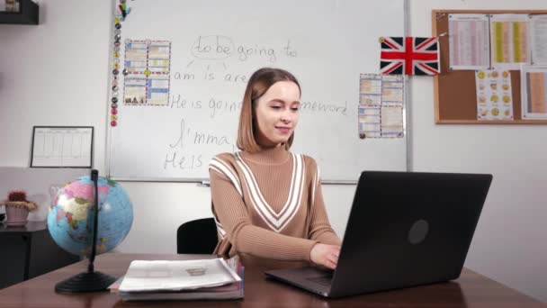 Professor Inglês Feminino Traje Casual Sentado Mesa Escola Fechando Laptop — Vídeo de Stock