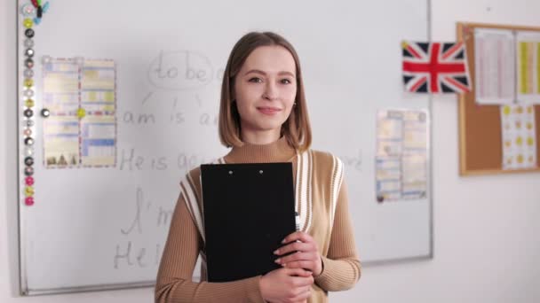 Portrait Cheerful Female Teacher Brown Hair Holding Hands Clipboard Young — Stockvideo