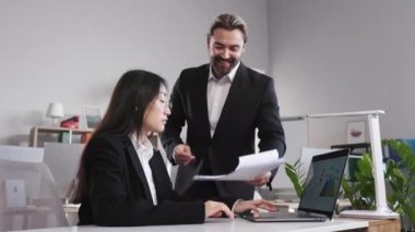 Heyecanlı erkek iş adamı, modern işyerinde iyi bir iş çıkaran kadın çalışanı tebrik ediyor ve kucaklıyor. İnsan kavramı, iş ve başarı.