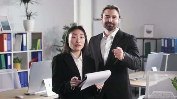 Handsome Caucasian Man Pointing Forefinger While Asian Woman Standing Clipboard — Stok video