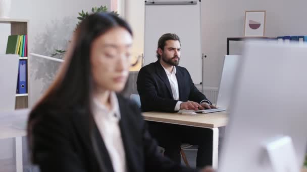 Bearded Businessman Sitting Desk Working Modern Computer Blurred Foreground Asian — Vídeos de Stock