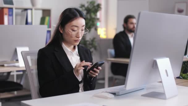 Focused Asian Woman Eyewear Black Suit Using Modern Smartphone Typing — Vídeos de Stock