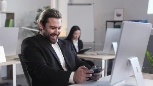 Joyfully Emotional Bearded Man Formal Wear Sitting Workplace Playing Games — Stockvideo