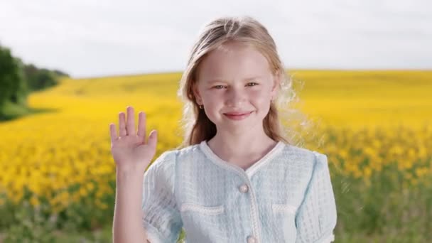 Portret Czarującej Białej Dziewczyny Machającej Ręką Uśmiechającej Się Patrzącej Kamerę — Wideo stockowe