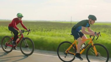 Anayol boyunca bisiklet süren özel spor ekipmanları giyen profesyonel bisikletçiler. İnsan kavramı, eğitim ve rekabet.