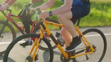 Spor elbiseli ve kasklı sarı bisikletli bir adam otoyoldaki kırmızı bisikletçiyi solluyor. Sıkı eğitim, rekabet ve hızlı yarış kavramı.