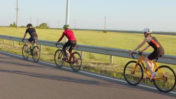 高速道路に沿ってスポーツ服やヘルメットサイクリングで白人男性と女性 新鮮な空気で競争する前に定期的にワークアウトをしているプロのサイクリスト — ストック動画