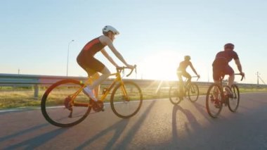Temiz havada bisiklet sürerken etkin giyimli ve kasklı beyaz erkek ve kadınların arka görüntüsü. İnsan kavramı, hobi ve yaşam tarzları.