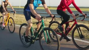 Açık havada profesyonel bisiklet kullanan sporcu erkek ve kadınlara yakın çekim. Aktif giyimli üç beyaz insan temiz havada en sevdiği hobiyi yapıyor. Spor ve bisiklet konsepti.