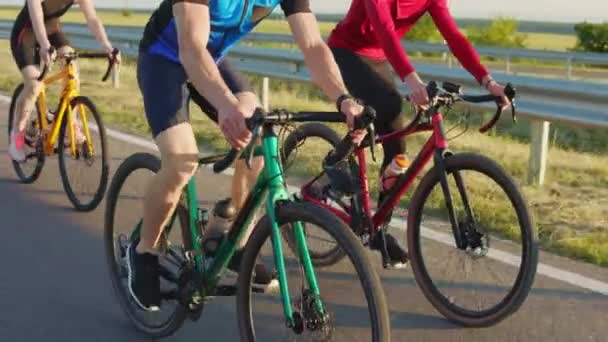 在沥青路面上 有3名骑着体形运动自行车的高加索骑自行车者 穿着运动服的快乐活跃的人在室外有氧运动上花时间 — 图库视频影像