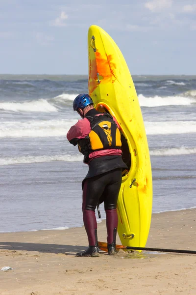 Muž připraven pozvednout kajak na pláži — Stock fotografie