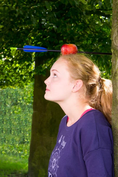 Chica con una manzana y flecha en la cabeza — Foto de Stock
