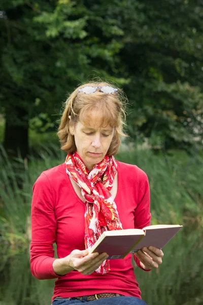 Mujer leyendo un libro en la naturaleza —  Fotos de Stock