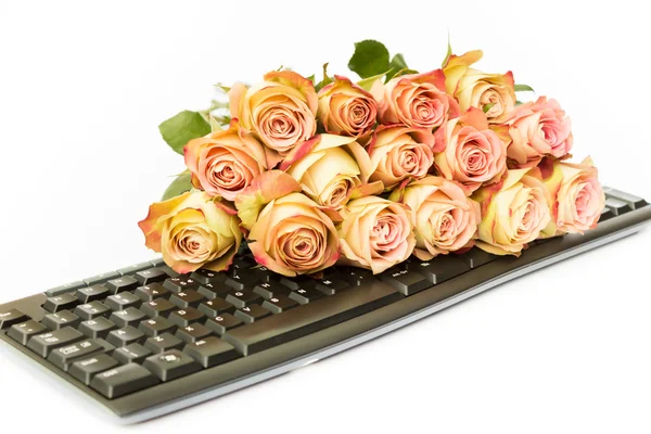 Ramo de rosas rosadas en el teclado de la computadora — Foto de Stock