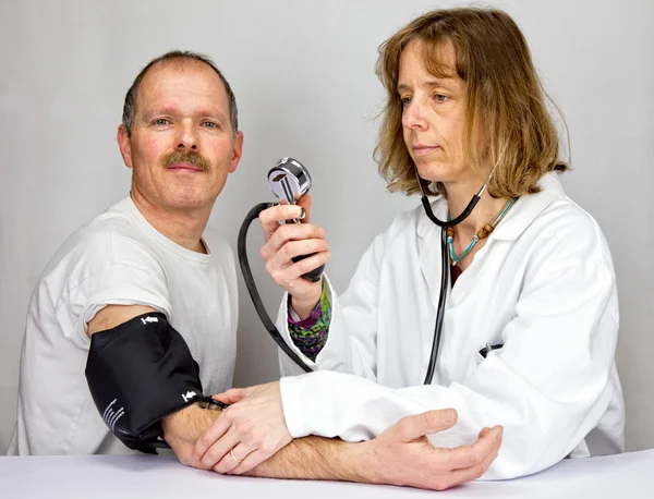 Doctor checks blood pressure of a patient — Stock Photo, Image