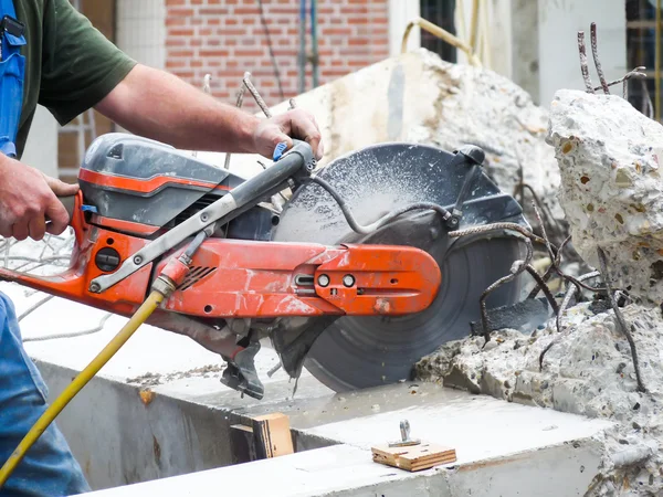 Arms holding grinder cutting concrete — Stock Photo, Image