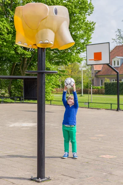 Jong meisje die gericht zijn bal op mand als olifant — Stockfoto