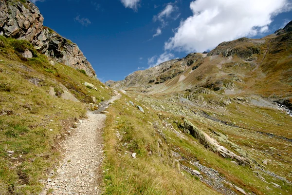 Felsweg führt ins Tal, umgeben von hohen Bergen in den Schweizer Alpen, Schweiz. — Stockfoto