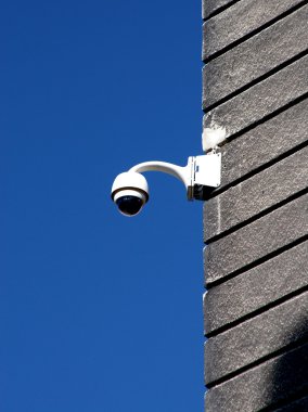 güvenlik kamerası alçı duvara karşı derin mavi gökyüzü kaplı