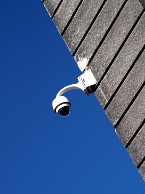 güvenlik kamerası alçı duvara karşı derin mavi gökyüzü kaplı