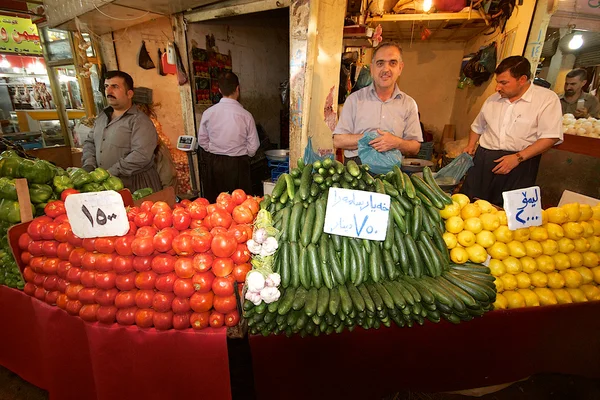 Tumpukan tomat, lemon dan paprika yang diatur dengan tepat di depan pedagang di pasar bazaar, Irak, Timur Tengah — Stok Foto