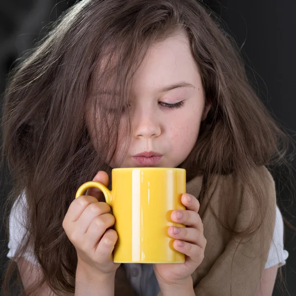 Ragazza che soffia sulla bevanda calda — Foto Stock