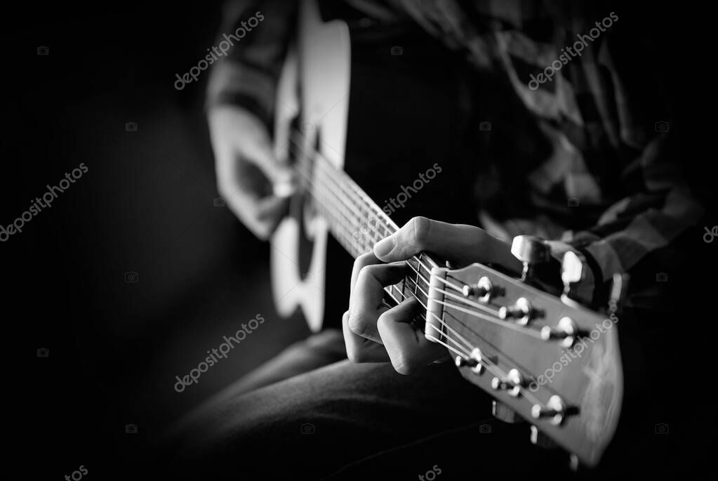 Guitarra tocando. Un joven toca la guitarra acústica. Primeros planos