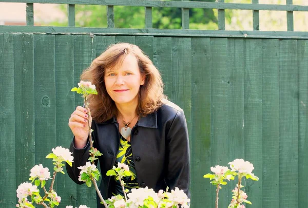 Mutlu ve çekici bir esmer bayanı yakalayıp minyatür bir elma ağacındaki çiçeği izlemenin keyfini çıkarıyorum..