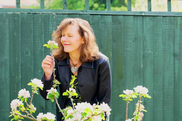 Mutlu ve çekici bir esmer bayanı yakalayıp minyatür bir elma ağacındaki çiçeği izlemenin keyfini çıkarıyorum..