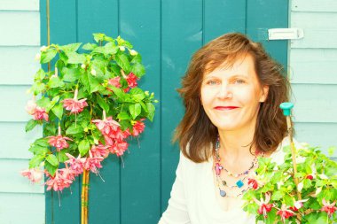 Çekici, esmer bir kadının Haziran 2022 'de çiçek açan standart fuşyalar sergilemesi..