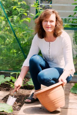 Serada yabani otları ayıklayan çekici esmer bir kadını yakalamak..