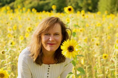 Ayçiçeği tarlasında göz alıcı ve çekici bir esmer kadın yakalıyorum..