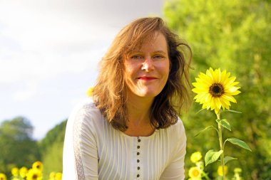 Ayçiçeği tarlasında göz alıcı ve çekici bir esmer kadın yakalıyorum..