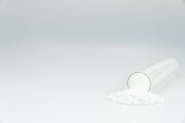 Ahşap arka planda beyaz plastik boncuklar polimer reçine, polimer palet petrokimyasal fabrikalardan alınmış ürünler. granüller polimer,