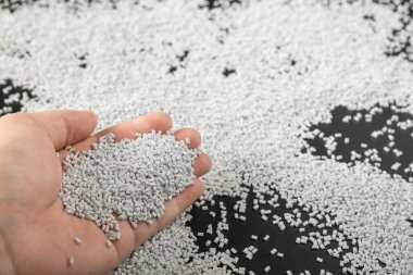 Ahşap arka planda beyaz plastik boncuklar polimer reçine, polimer palet petrokimyasal fabrikalardan alınmış ürünler. granüller polimer,
