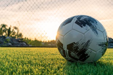 Güneş doğduğunda futbol ya da futbol topunu kapat. Futbol topu kaleye uçtu. Futbol topu ağı büker. Gol atmak için. Futbol oyuncularının yakın plan Yeşil sahada topa basmaları.