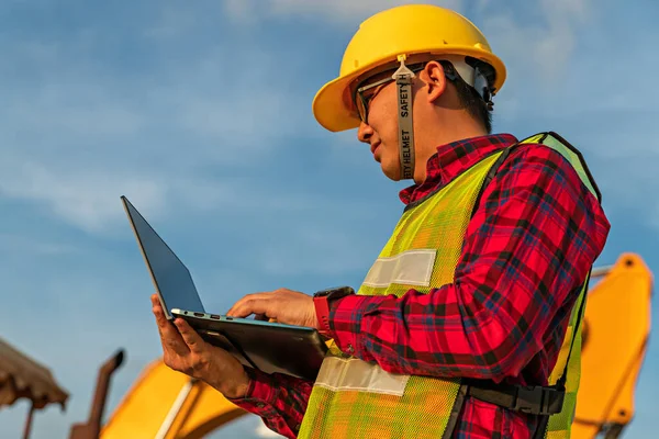 Asyalı mühendisler kazıcı tarafından yapılan toprak taşıma projesi için ekiple telsiz konuşmaları kullanırlar. Ustabaşı inşaat projesi için dizüstü bilgisayar kullanıyor. İşçi endüstrisi için makine ve ekipman.